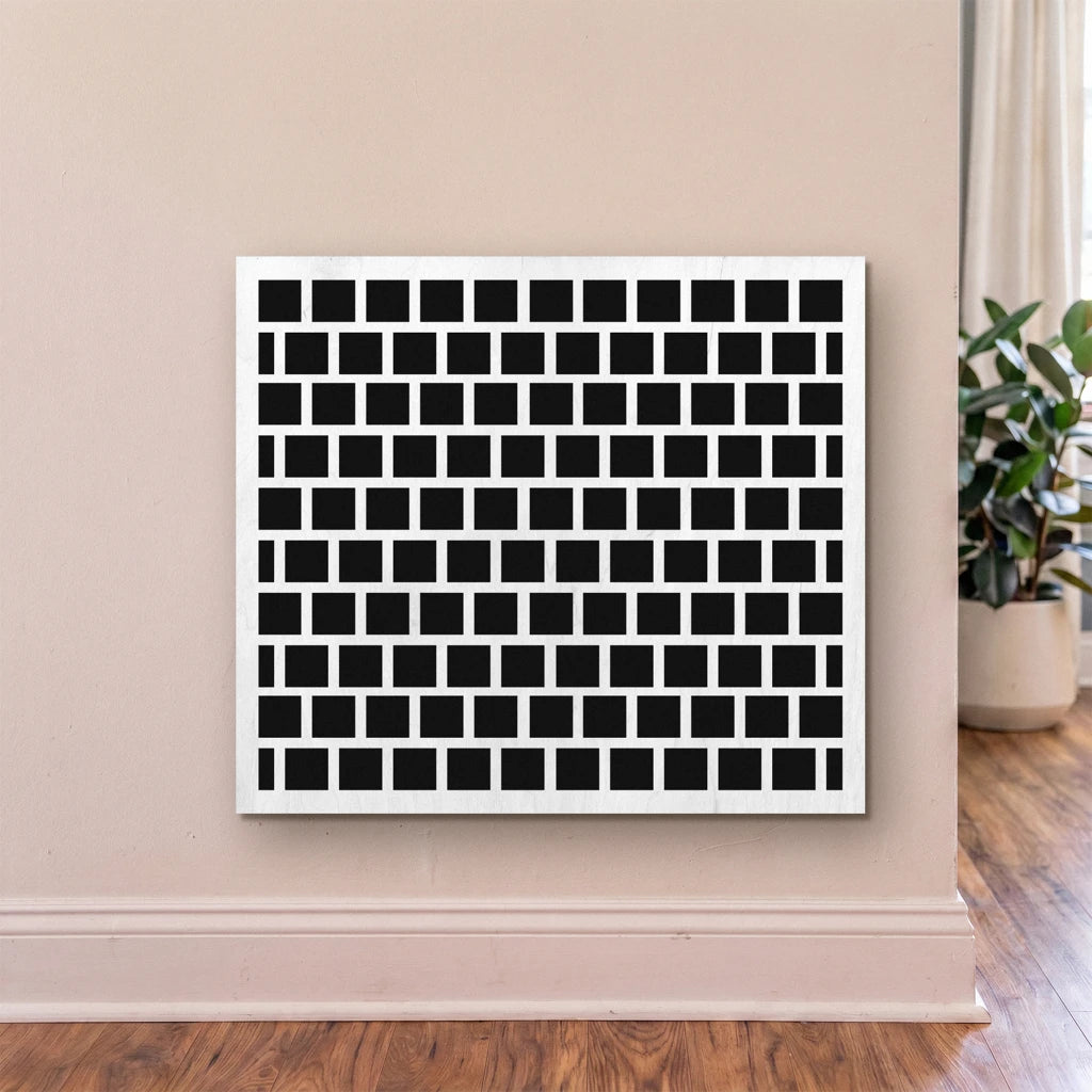 Black and white geometric patterned wall art on a beige wall.