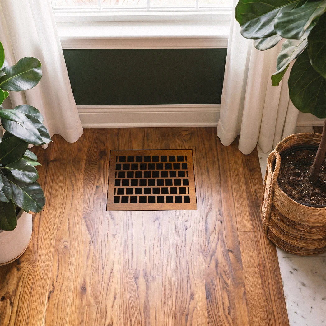 Wooden floor vent with plants on either side in a room with a window and white curtains.