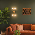 Living room with a brown sofa, decorative pillows, and wall sconces.
