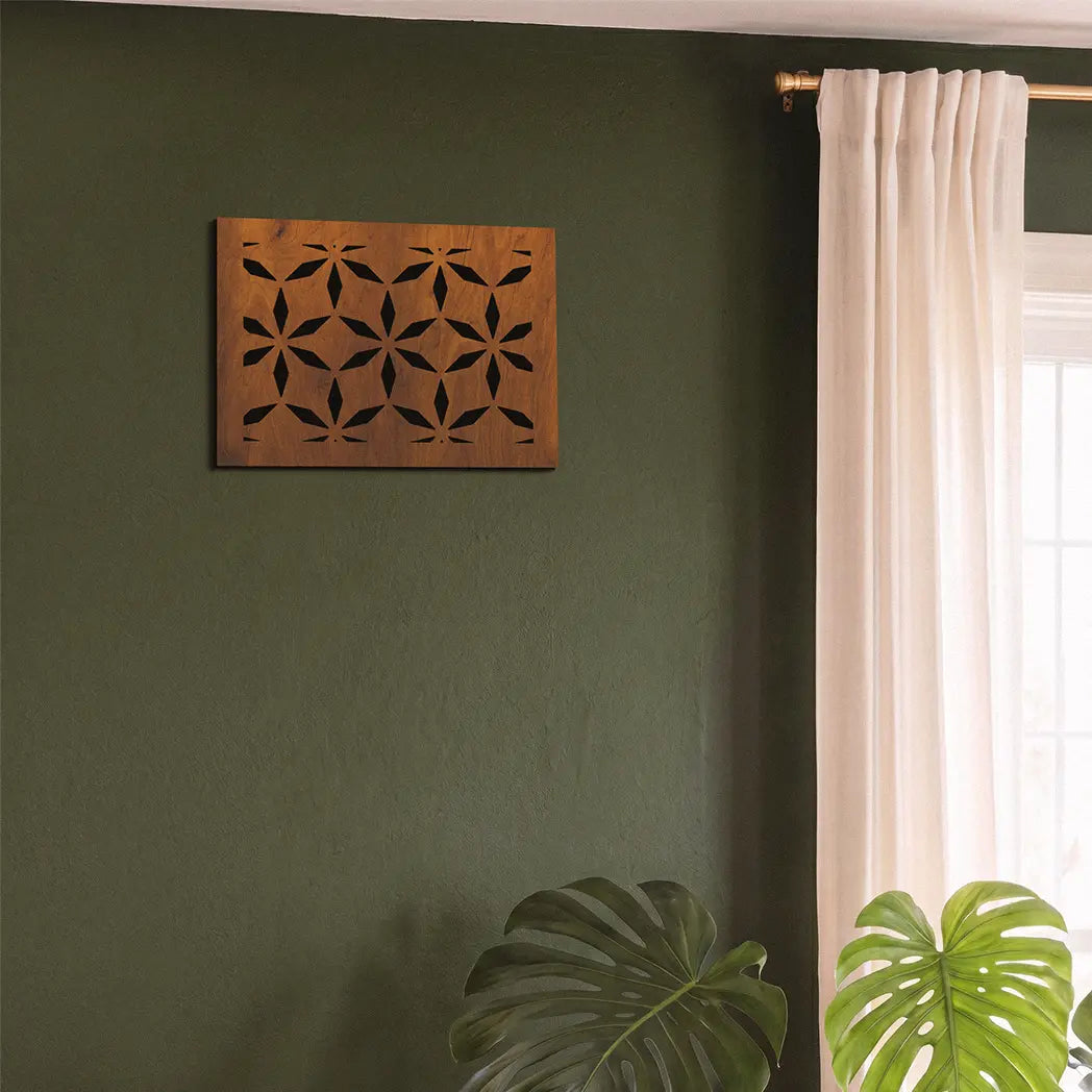 Decorative wooden panel on a green wall with a window and plant in the background